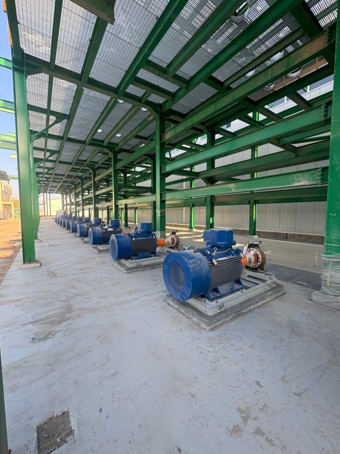 Electric motor-driven pumps installed in a row under a steel canopy